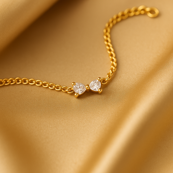 Macro shot of Celeste Minimal Gold Bracelet on satin background, showcasing twin zircon sparkle.